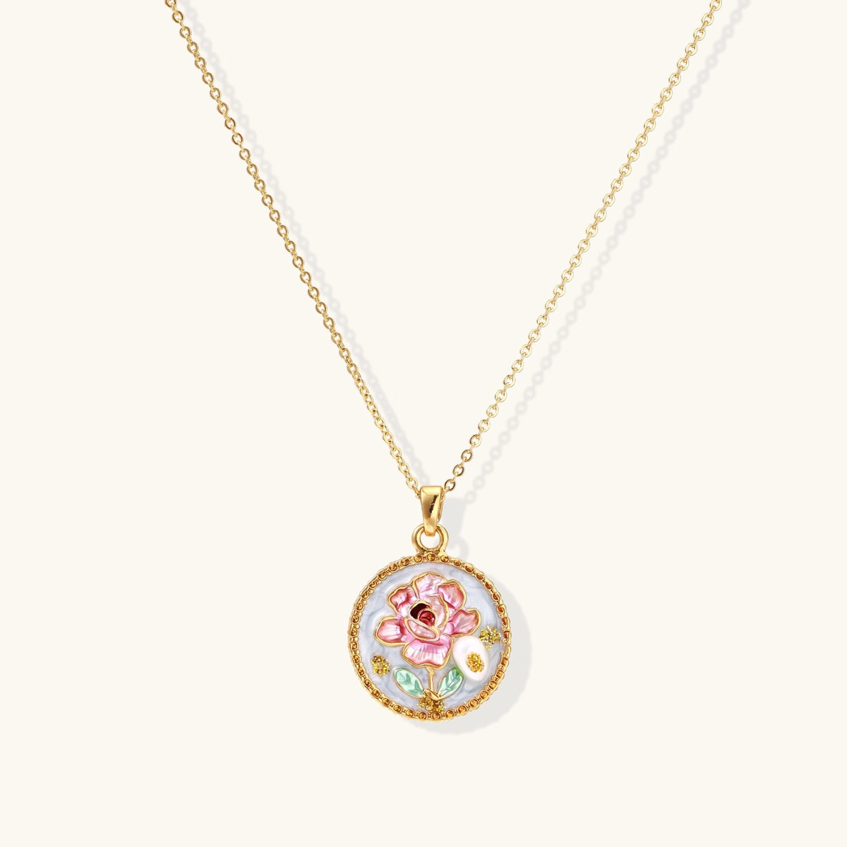 Gold-plated circular pendant with pink enamel rose, pearl background, and delicate beaded border on chain